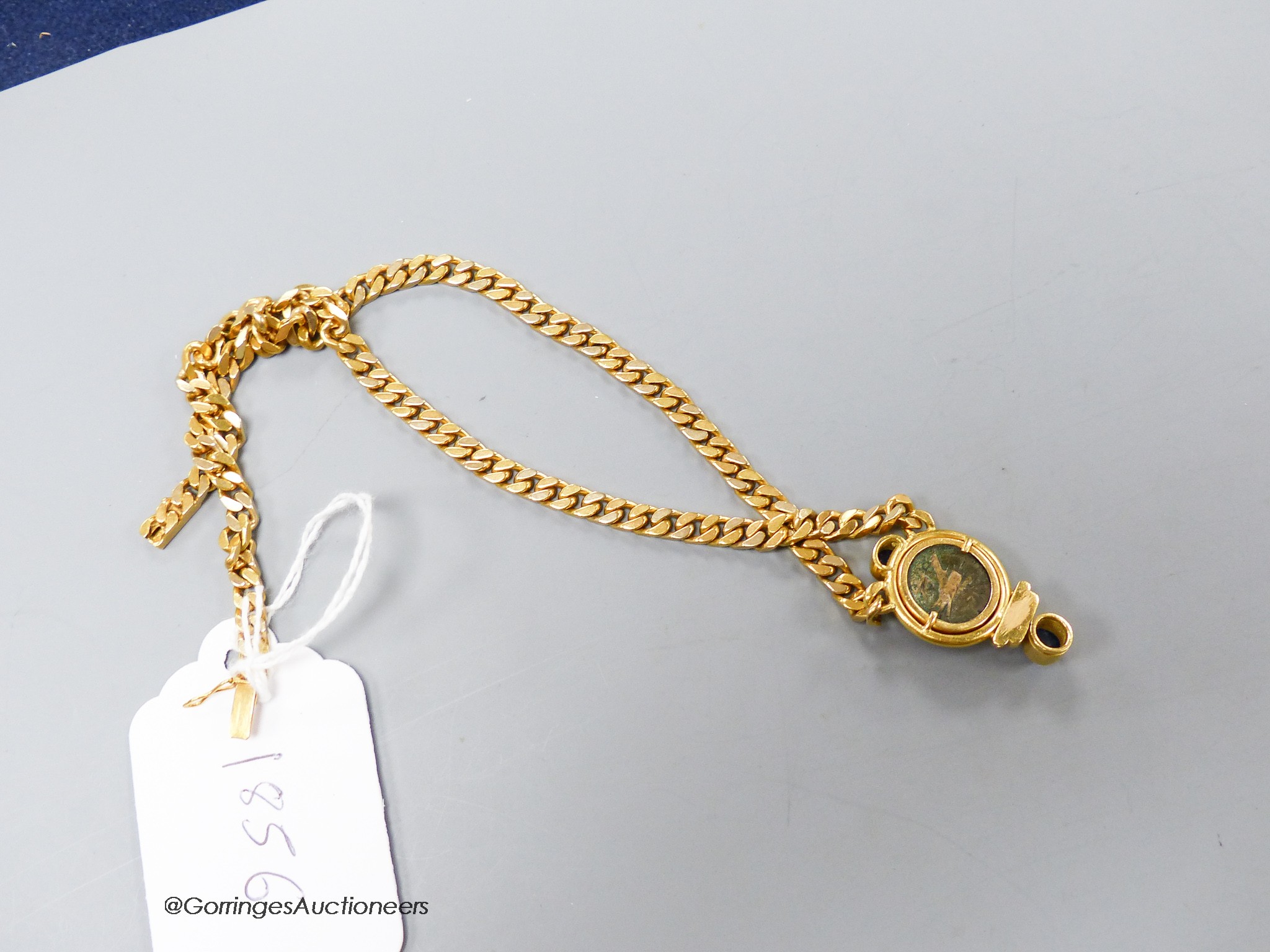 A modern curb link yellow metal, inset coin, blue cabochon stone and diamond set pendant necklace, 43cm, gross weight 47.3 grams.